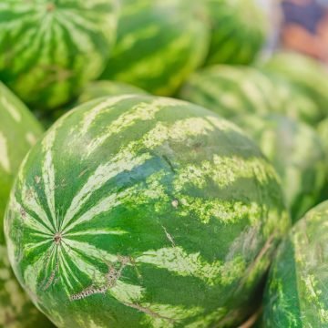 Blurred background of watermelons in the market, background and screensaver idea for advertising or seasonal products store